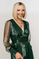 Three-quarter view of the Layla Tulle Maxi Dress in Dark Green Multi showing flowing skirt, smocked cuffs, and delicate floral pattern across bodice.