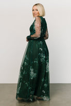Model wearing Layla Tulle Maxi Dress in Dark Green Multi on a neutral background; deep V-neck, sheer sleeves, smocked waist and full lining shown.