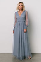 Three-quarter shot of the whisper-blue Layla Tulle Maxi Dress highlighting sheer long sleeves with smocked cuffs and the dress’s layered tulle texture.