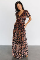Full-length studio image of Leslie embossed velvet maxi dress in Black + Bronze, highlighting V-neck, gathered waist, and soft skirt movement.