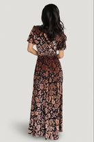 Back view of Leslie embossed velvet maxi in Black + Bronze showing maxi length hem, seam lines, and overall movement of fabric.