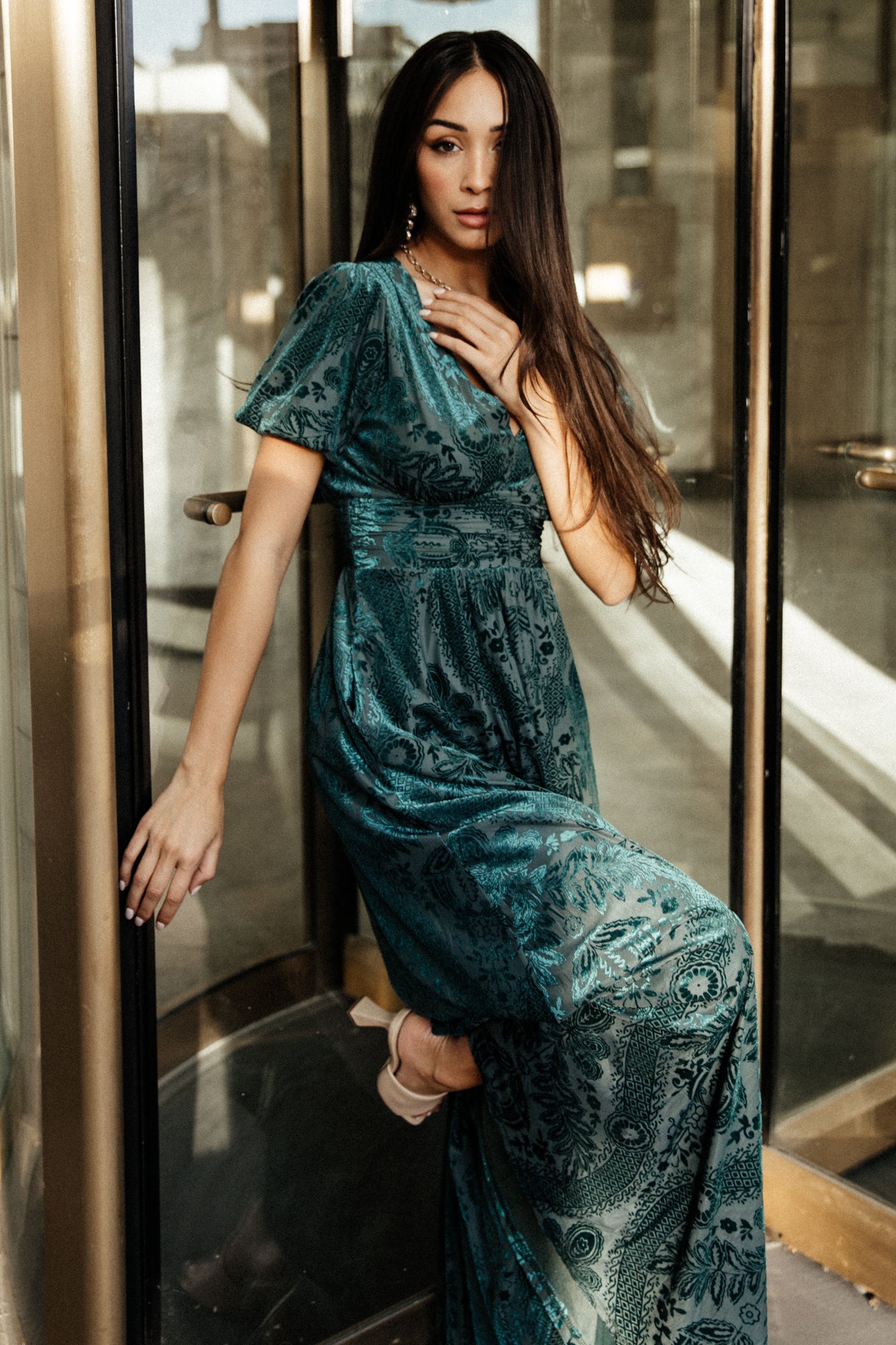 Full-length studio image of the Leslie emerald velvet maxi on a model, presenting silhouette, length, and polished finish.
