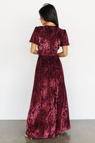 Model wearing the Mulberry velvet maxi dress walking to show skirt movement, full lining and floor-skimming length.