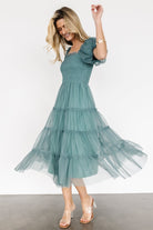 Side view of eucalyptus tulle midi dress in motion, emphasizing tiered skirt movement, puff sleeve detail, and overall midi length.