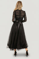 Back view of the Lonnie Tulle Dress in black showing the hidden zipper at the bodice, satin waist tie and tiered tulle skirt for added volume.