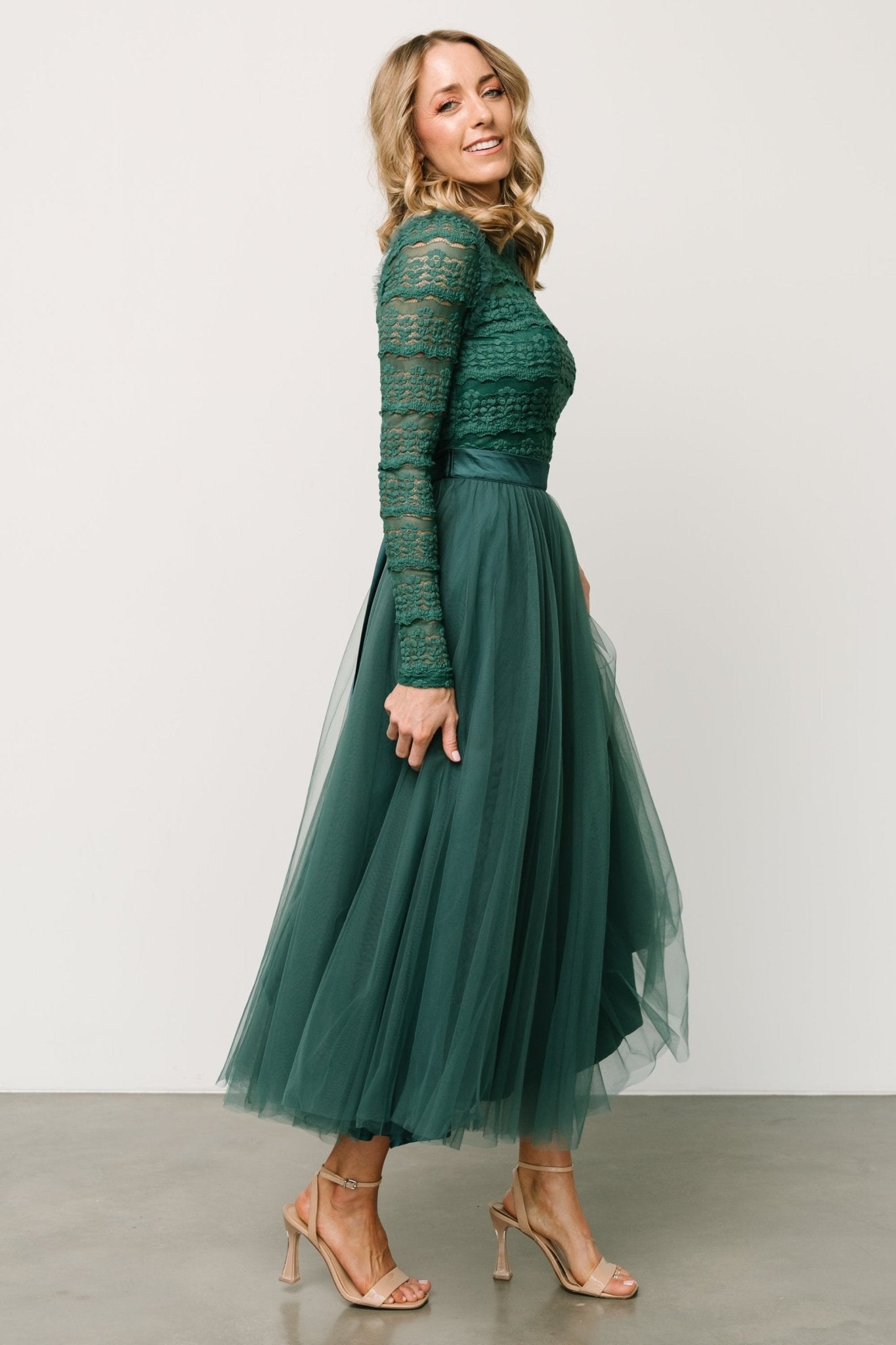 Side view of the emerald Lonnie Tulle Midi Dress on model, showing sleeve shape, elastic cuff detail and the satin waist tie knot.
