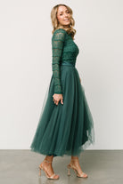 Side view of the emerald Lonnie Tulle Midi Dress on model, showing sleeve shape, elastic cuff detail and the satin waist tie knot.