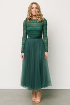 Model movement shot in emerald tulle skirt, illustrating skirt sweep, midi length and gentle sheerness of outer layers.