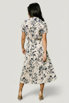 Detail of the removable waist sash tied in a bow, highlighting styling options and waist definition for the midi silhouette.
