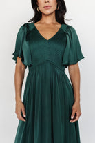 Side view of Lovell Smocked Midi Dress in emerald highlighting flutter sleeves and lined skirt movement.