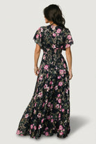 Side view of the Lynlee metallic maxi dress in dark blue + pink, featuring the smocked waist, flutter sleeve profile, and flowing layered skirt.