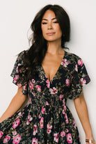 Back and movement view of the Lynlee metallic maxi dress in dark blue with pink print, showing the full skirt and delicate metallic sheen in sunlight.