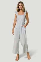 Close-up of the sweetheart neckline and ruffle tank sleeve on the blue Madison denim jumpsuit showing stitching detail.