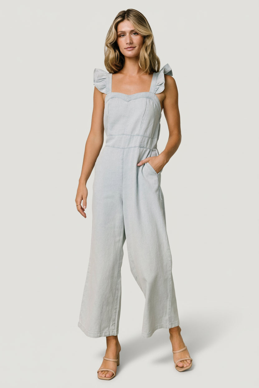 Close-up of the sweetheart neckline and ruffle tank sleeve on the blue Madison denim jumpsuit showing stitching detail.