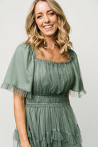 Side view of Magdalena Tulle Maxi Dress in dark eucalyptus, displaying elastic waistband and flowing tiered skirt movement.