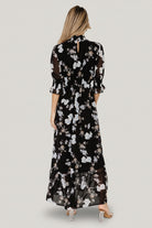 Styled hero shot of the maxi dress on a model, showing overall silhouette, modest coverage, and floor-skimming single-tier skirt.