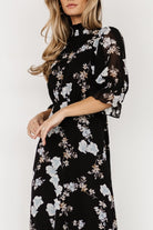 Three-quarter angled view of floral chiffon maxi showing pleated front waist, elastic back waist shaping, and gentle movement of the skirt hem.