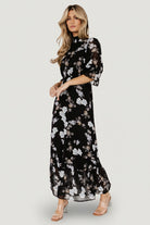 Close-up of fabric print and weave, showing black chiffon base with slate-blue floral motifs and the garment's delicate finish.