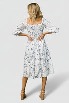 Detail shot of the 3/4 ruffle sleeve and elastic cuff on the Marta Smocked Midi Dress in white and blue floral.