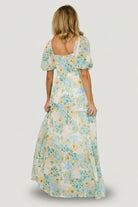 Editorial-style image of Maya Maxi Dress in Garden Multi, emphasizing the flowing chiffon tiers, keyhole detail, and elastic-cuffed sleeves.