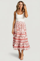 Full-length photo of Meg skirt in blush multi floral pattern styled with a tucked top, highlighting midi length and tiered ruffle silhouette on model.