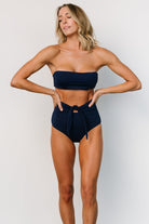 Side profile of Milos navy bandeau bikini top on model, highlighting clean seamlines, natural shaping, and the adjustable tie-back closure.