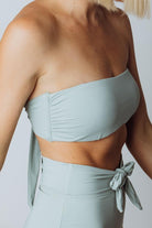 Side view of Milos sage bandeau bikini top demonstrating low-profile silhouette, removable padding, and smooth finish.