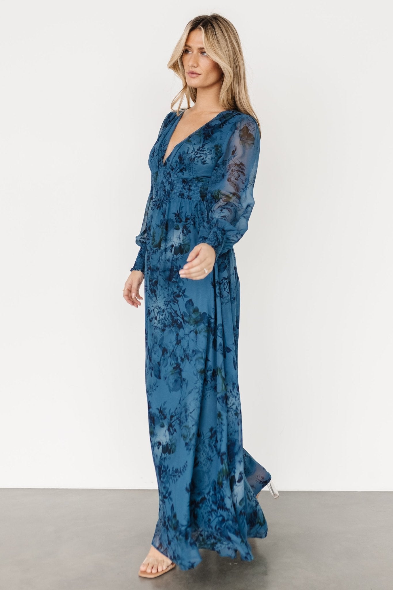 Detail image of bodice and neckline, showing the deep V-neck, lining and the dress's floral pattern in close view.