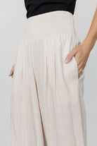 Close-up of the smocked elastic waistband and linen-rayon texture on the Parvati pants in a soft natural hue.