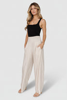 Three-quarter shot of Parvati smocked waist pants in natural; wide leg drape, lightweight linen-rayon fabric, unlined finish visible.