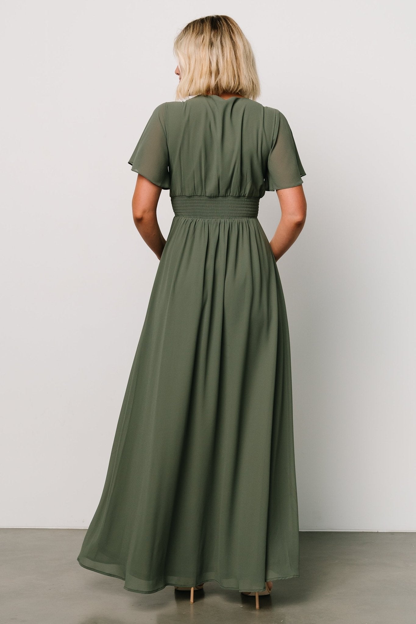 Detail shot of the V-neckline and flutter sleeve on the Ramona Maxi Dress in dark sage, highlighting feminine shaping.