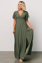 Three-quarter view showing Ramona Maxi Dress in dark sage with flutter sleeves, empire ruching, and graceful chiffon movement.