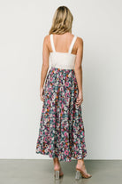 Model walking in the navy floral maxi skirt, displaying drape, movement, and full length for a relaxed silhouette.