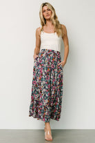 Close-up of navy floral rayon fabric showing multicolor flower print, texture, and a partial lining peek at the hem.