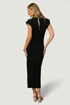 Detail shot of left leg slit and flowing skirt on Sasha ruched maxi dress in black, highlighting movement and clean finish.