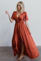 Image focusing on the flutter sleeve and shoulder seam of the rust satin maxi to show sleeve length and fabric texture.