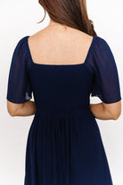 Close-up of sweetheart neckline and elastic shoulder detail on the navy chiffon maxi dress, showing seam finish and lining edge.