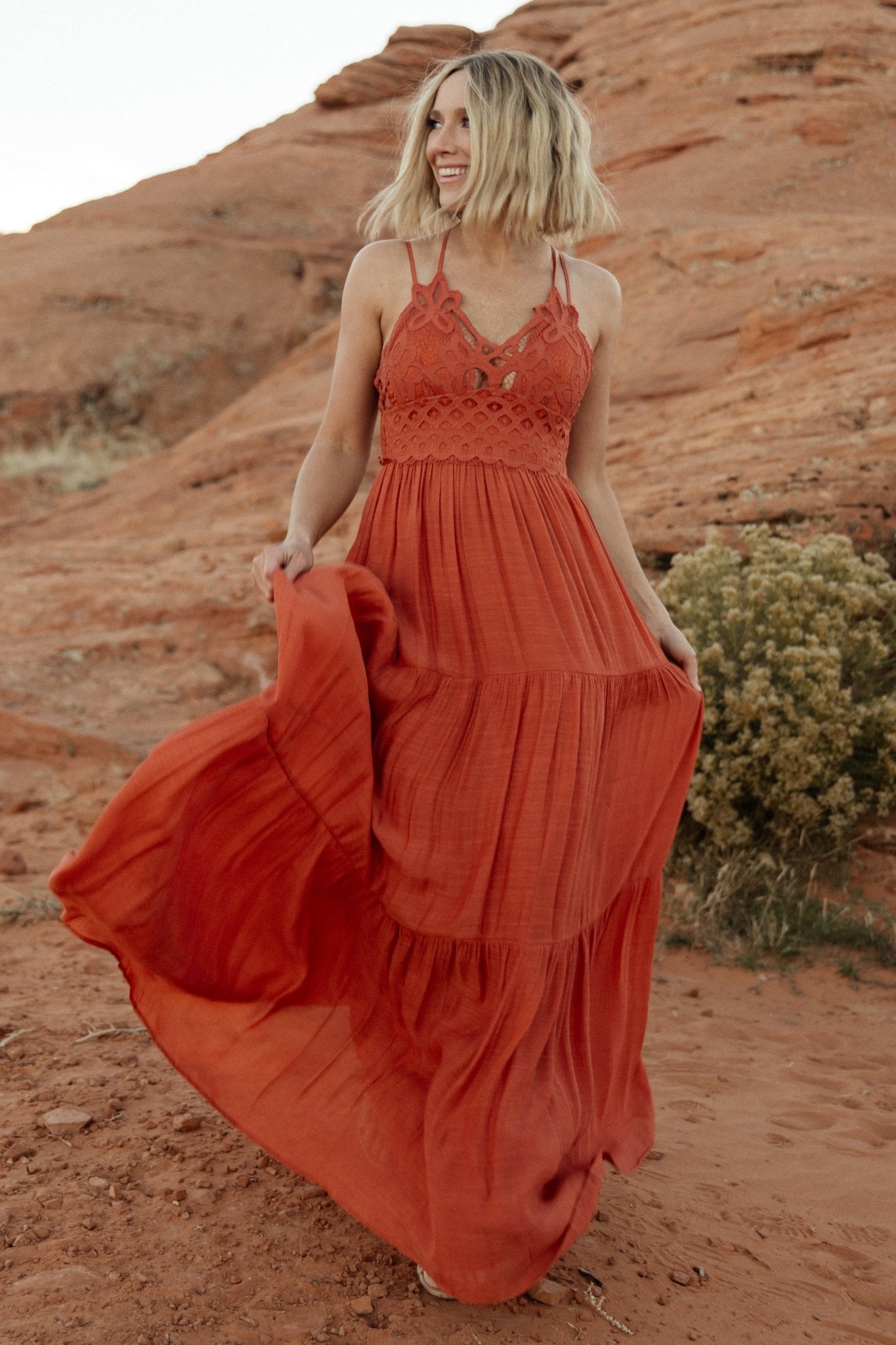 Studio shot of rust lace top maxi dress on mannequin showing tiered silhouette, hemline length, and lined construction.
