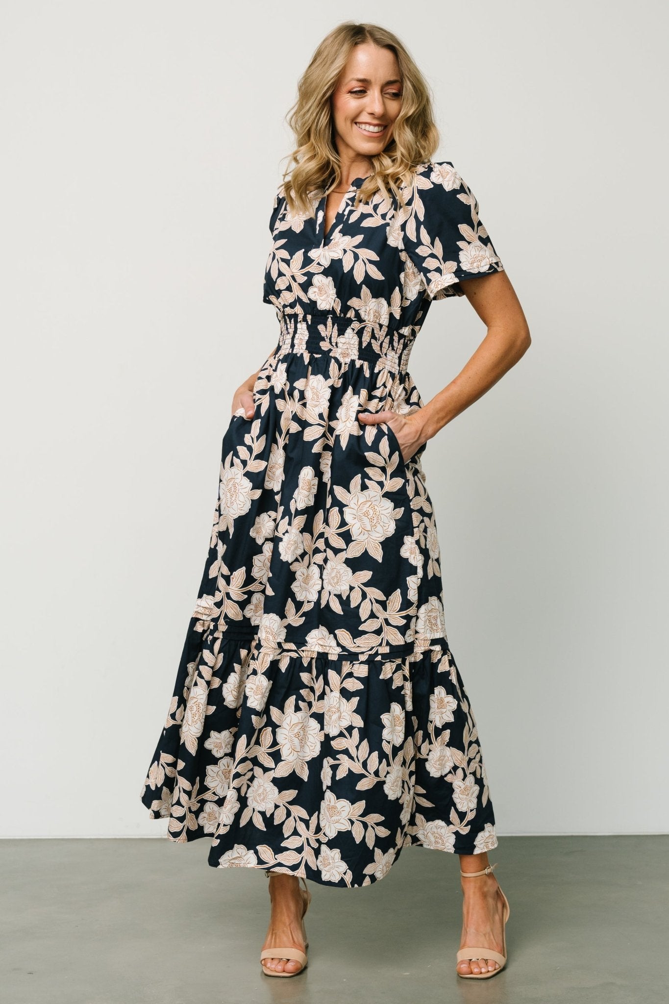 Detail image of the Vera Maxi Dress in navy floral focusing on the functional side pocket, tiered skirt seam and delicate floral print.