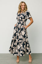 Detail image of the Vera Maxi Dress in navy floral focusing on the functional side pocket, tiered skirt seam and delicate floral print.
