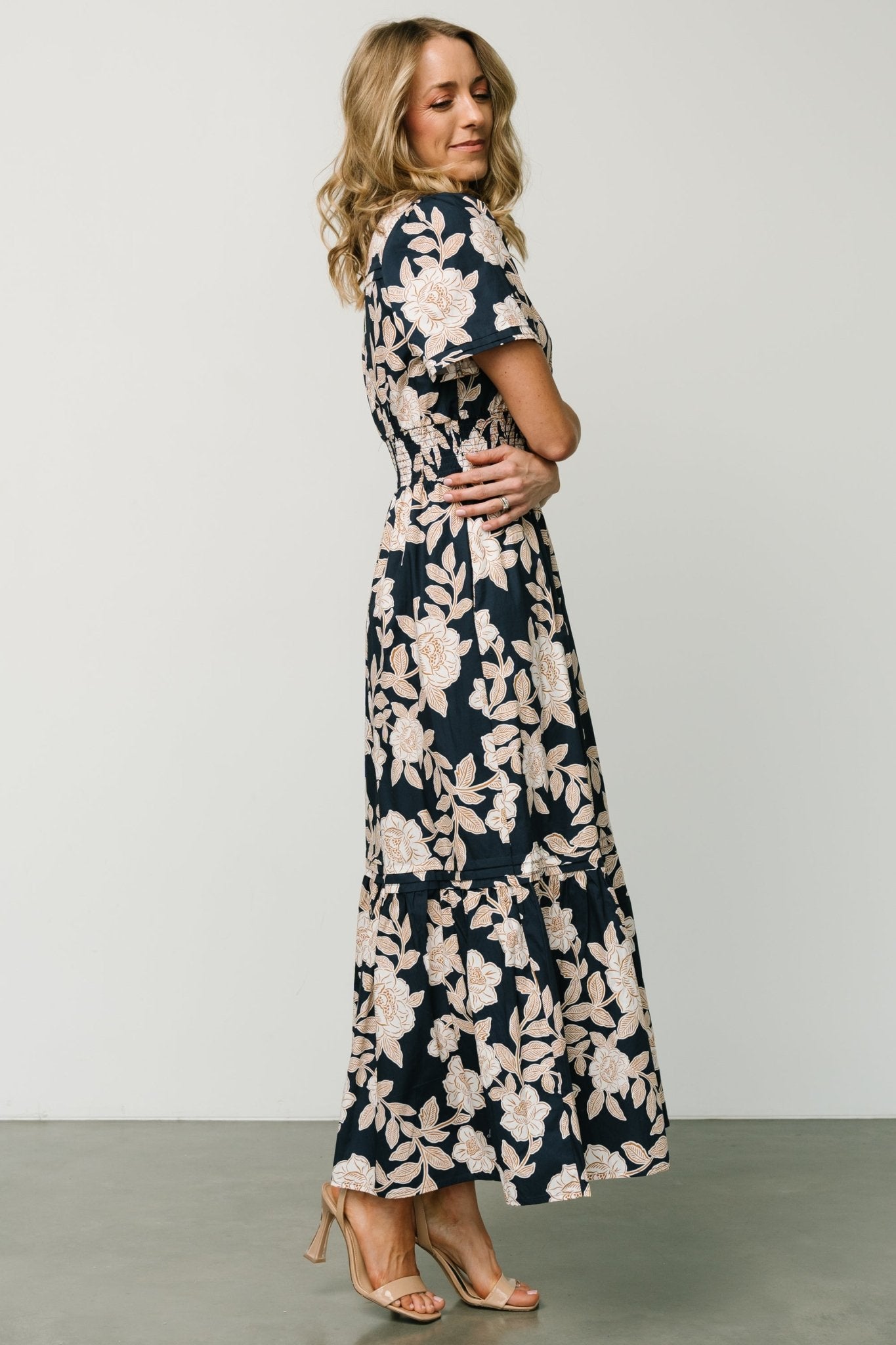 Flat-lay or studio image of Vera Maxi Dress in navy floral highlighting the print, notched V-neck, smocked waist and unlined cotton construction.