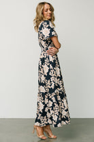 Flat-lay or studio image of Vera Maxi Dress in navy floral highlighting the print, notched V-neck, smocked waist and unlined cotton construction.